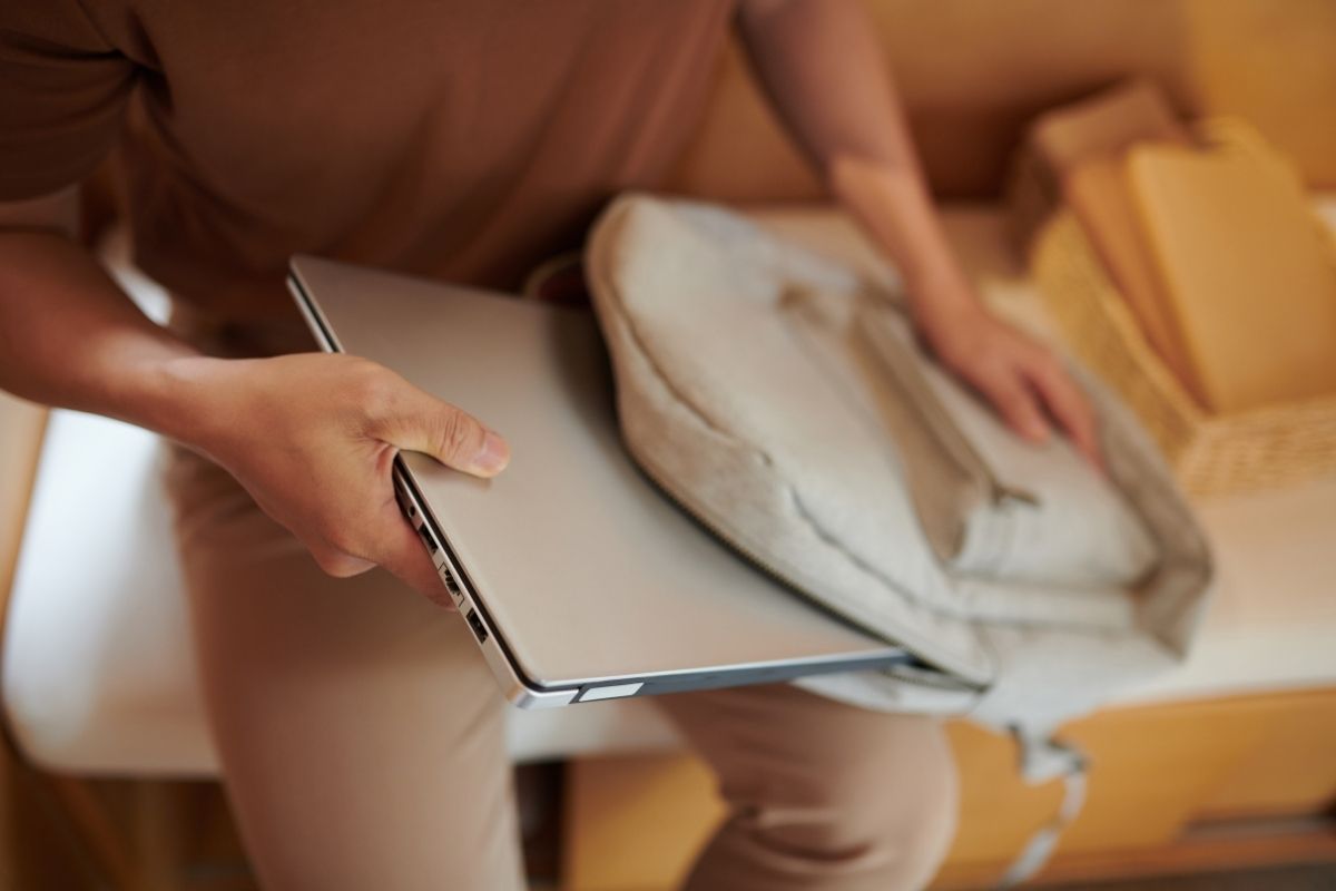 Uomo che infila il laptop nel suo zaino